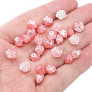 Détail macro de perles camélia rose nacré pour la création de bijoux DIY à la main