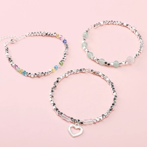 Three elegant beaded bracelets with silver alloy spacers and colorful gems on pink background