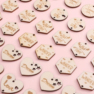 DIY laser-cut natural wood pendants with engraved inspirational words on pink backdrop