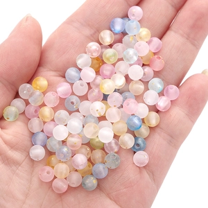 Bunte matte Acrylperlen mit Goldfolie in der Hand für DIY-Schmuckherstellung