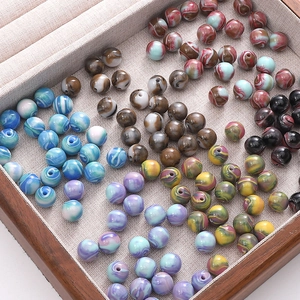 Vue macro de perles en résine à texture marbrée de diverses couleurs pour la création de bijoux