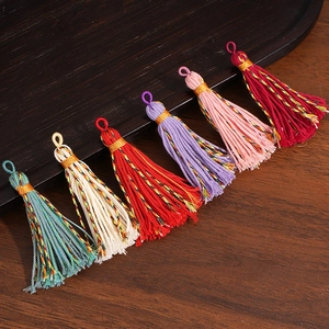 Detail of multi-colored cotton tassel pendants with gold thread neck for DIY crafts