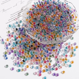 Macro shot of colorful faceted glass seed beads scattered in a textured crystal dish