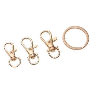 Detailed view of four golden lobster clasps and flat metal rings for DIY jewelry making