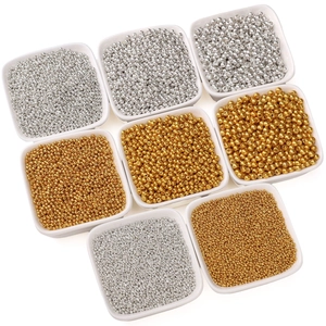 Mixed set of gold and silver glass seed beads in white ceramic dishes for DIY jewelry