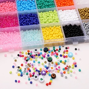 Vue détaillée de perles de rocailles colorées et alphabétiques dans leur boîte de rangement