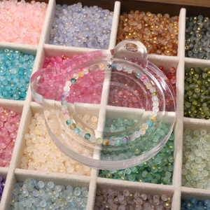 Macro view of 4mm frosted glass beads with gold dust finish in a sorting tray for DIY jewelry