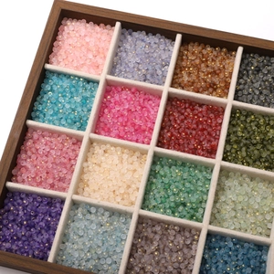 Macro detail of 16-color 4mm frosted glass beads with gold dust in wooden organizer box