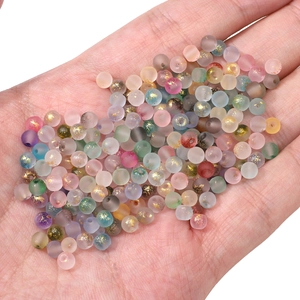 Hand holding 4mm frosted glass beads with gold foil for DIY jewelry making accessories