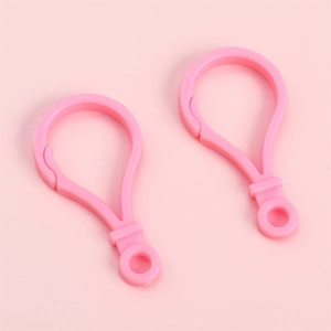Gros plan de deux fermoirs mousquetons roses pour bijoux DIY et accessoires de porte-clés