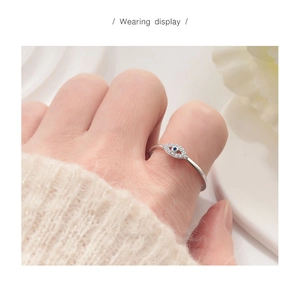 Detailed view of an S925 sterling silver evil eye ring with blue stone on a finger