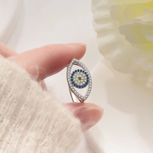 S925 sterling silver evil eye ring with blue stones and crystals held by a hand