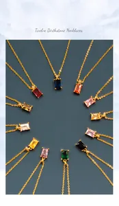 Detailed overhead view of twelve gold necklaces with colorful rectangular birthstones