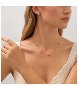 Detail of gold-plated star and moon necklace and earrings set worn by a model