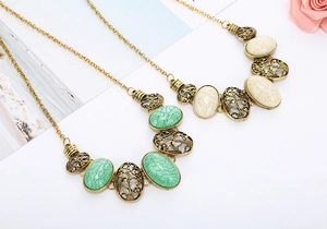 Close-up of vintage hollow oval stone pendant necklace in green and beige marble finish