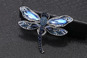 Gros plan d'une broche libellule vintage avec strass bleus et détails en alliage argent