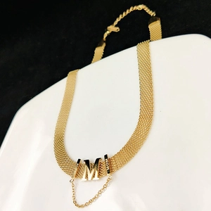 Golden woven mesh choker necklace with M pendant and MOM engraving on white ceramic