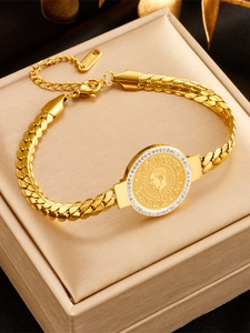 Detailed shot of a gold-plated stainless steel coin bracelet with a portrait and zircons