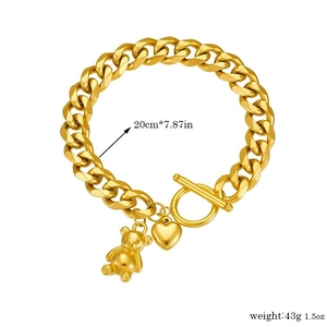 Detail eines goldenen Panzerarmbands mit OT-Verschluss, 3D-Bär und Herzanhänger, 20 cm