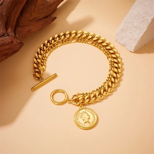 Detailaufnahme des goldenen Panzerketten-Armbands mit Elizabeth-Münze und OT-Knebelverschluss