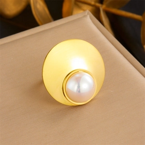 Brushed gold ring featuring a large concave base and a central cream pearl inlay