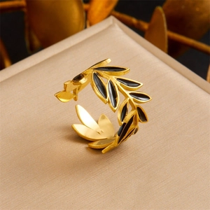 Detail of adjustable gold-plated branch ring with elegant black enamel leaf design