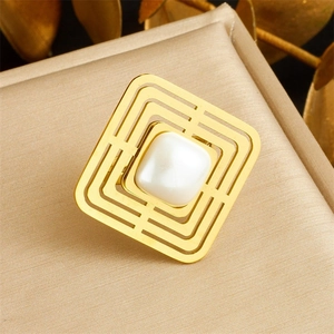 Detail of gold-plated square open ring featuring a white pearl inlay on satin display