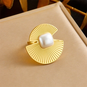 Detailed macro view of gold-plated fan-shaped ring with a square pearl on leather background