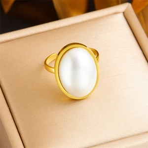 Detail of adjustable gold ring with large oval pearl on champagne silk texture