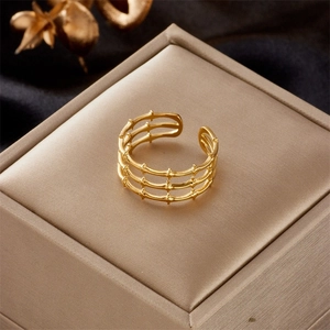 Detail of adjustable gold-plated layered ring with textured finish on black velvet display