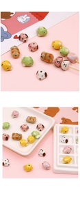 Detailed view of hand-painted ceramic dog and panda beads for DIY jewelry making