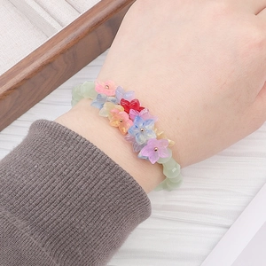 Détail d'un bracelet en perles fait main avec pétales de cerisier colorés en verre