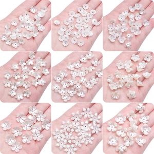 Macro detail of nine different pearl white flower petal spacer beads for DIY jewelry