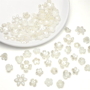 Macro view of white ABS pearl flower petal spacer beads for DIY jewelry making
