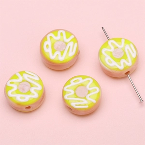 Detailansicht gelber Donut-Perlen mit Crememuster für DIY-Schmuckherstellung