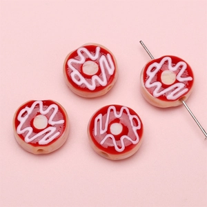 Makroaufnahme von handgefertigten Donut-Perlen für Schmuck mit rosa Wellenmustern