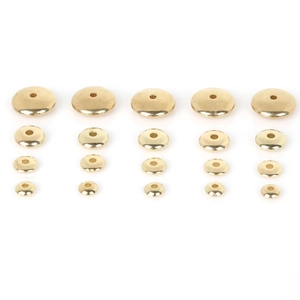 Detailed macro view of gold-plated CCB flat round spacer beads in four different sizes
