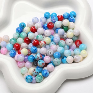 Macro shot of 8mm marbled glass beads in ceramic dish for DIY jewelry making and necklaces