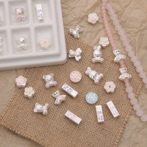 S925 sterling silver beads with rabbit, flower shapes and enamel details on linen background
