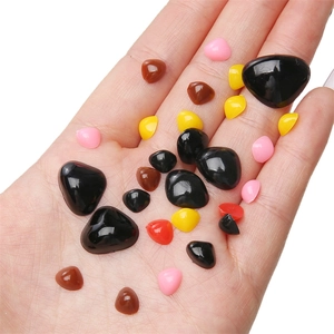 Multi-colored triangular acrylic animal noses for DIY plush toys held in palm for scale