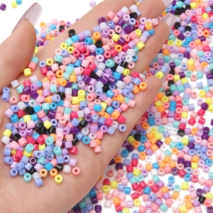Macro shot of colorful 4mm acrylic cylinder beads for DIY jewelry making held in hand