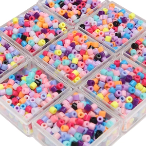 Macro detail of 4mm colorful acrylic cylinder beads sorted in a clear storage box