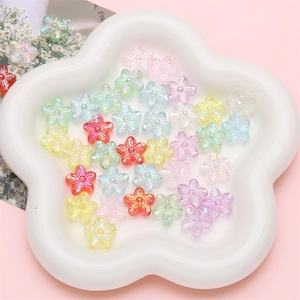 Bunte irisierende Acryl-Blütenperlen in einer weißen Keramikschale für DIY-Schmuck