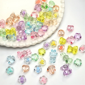 Vue macro de perles en acrylique transparentes en forme de cœur, d'ours et de fleurs DIY