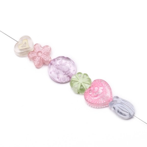 Detailed macro view of assorted acrylic pastel heart and flower beads on a wire strand