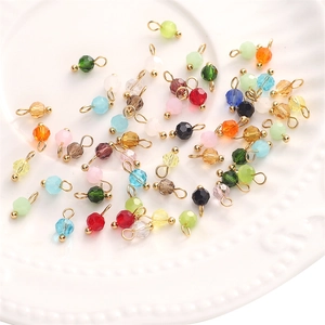 Vue macro de breloques en cristal de verre coloré facetté de 4mm avec boucles dorées pour DIY
