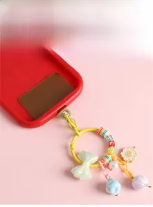 Close-up of red phone case with colorful resin rainbow beads and bow charm accessory