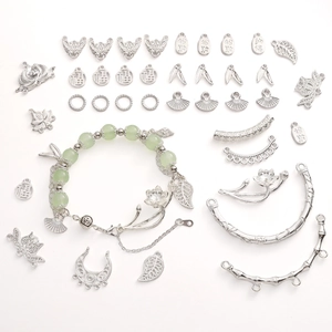 Detail of silver alloy lotus, leaf pendants and green jade-like beads for DIY bracelets