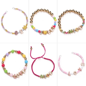 Colorful 10mm alloy letter beads and braided bracelets with gold accents on white background