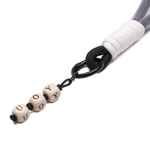 Macro view of hand-woven polyester lanyard with square wooden beads and metal ring